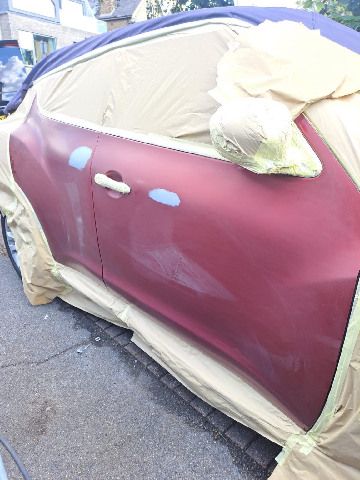 Red car side panel before final bodywork refinishing